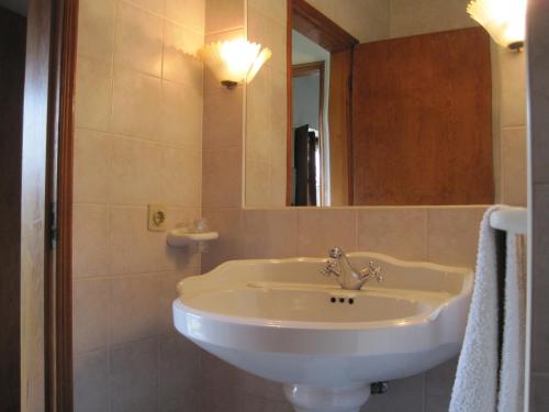 ein Badezimmer mit einem weißen Waschbecken und einem Spiegel in der Unterkunft Casa do Retiro in Pedrógão Grande