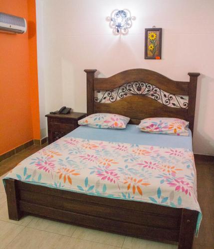 a bedroom with a bed with a wooden headboard at Posada El Abuelo in Cúcuta