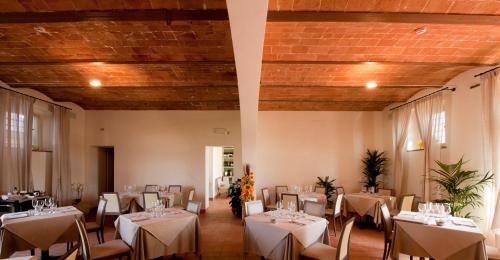 a dining room with tables and chairs in a building at Locanda Sant'Agata in San Giuliano Terme