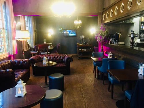 a restaurant with couches and tables and a bar at Le Cheval Blanc in Jargeau