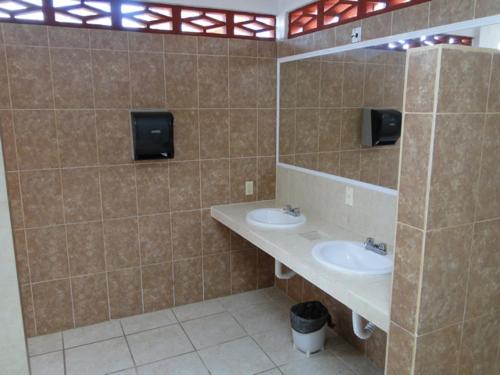 a tiled bathroom with two sinks and a mirror at Paraiso del Pescador in Rincon de Guayabitos