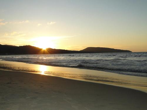 a sunset on a beach with the ocean at Paraiso del Pescador in Rincon de Guayabitos