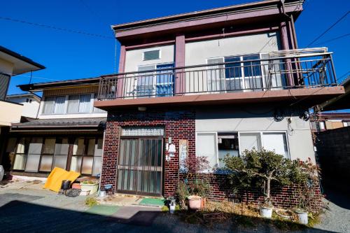 a house with a balcony on top of it at Habitacion NIIYA Mt Fuji in Fujikawaguchiko