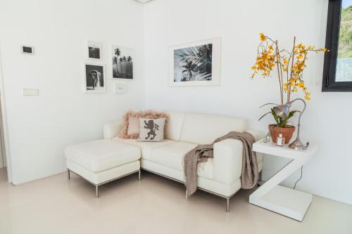 a white living room with a white couch and a table at Villa Alkaram de lujo con vistas panorámicas al mar in Zahara de los Atunes