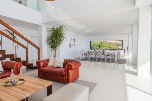 a living room with two chairs and a table at Villa Alkaram de lujo con vistas panorámicas al mar in Zahara de los Atunes