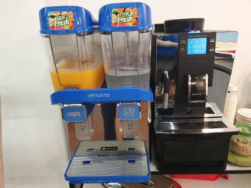 a blender with a glass of orange juice in it at The Beauty Hotel in Gangneung