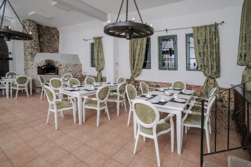a dining room with tables and chairs and a fireplace at Designpension Traumschloss Hotel Garni in Wernigerode