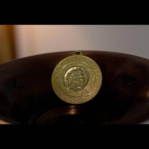 a gold coin sitting on top of a brown purse at Villa Agno - Βίλα Αγνώ in Ãno KariaÃ­