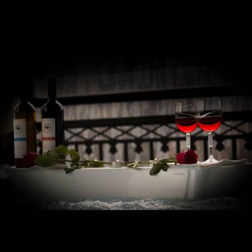 two glasses of wine sitting on a table with wine bottles at Villa Agno - Βίλα Αγνώ in Ãno KariaÃ­