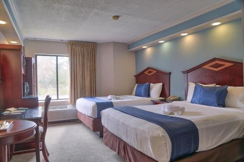 um quarto de hotel com duas camas e uma mesa em Destiny Palms Hotel Maingate West em Kissimmee