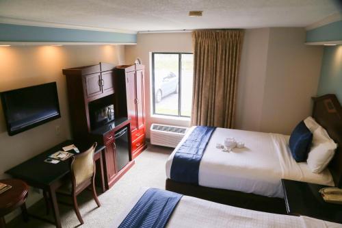 a hotel room with a bed and a desk and a room at Destiny Palms Hotel Maingate West in Kissimmee