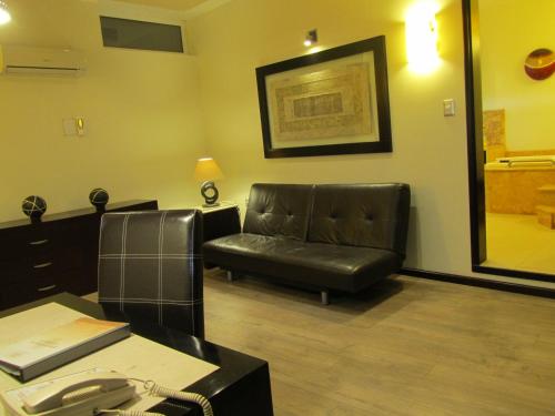 a waiting room with a leather chair and a phone at Hotel Colonial in Teziutlán
