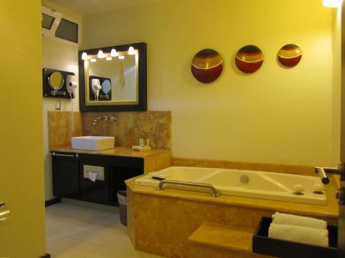 a bathroom with a tub and a sink and a mirror at Hotel Colonial in Teziutlán