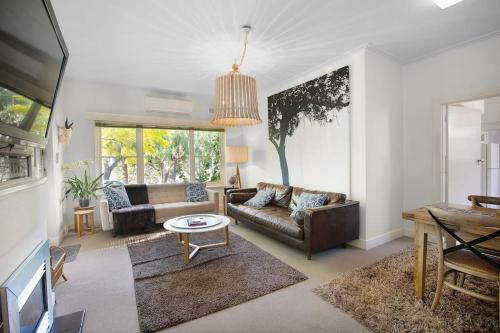a living room with a couch and a table at The Beach House Apartment in Geelong
