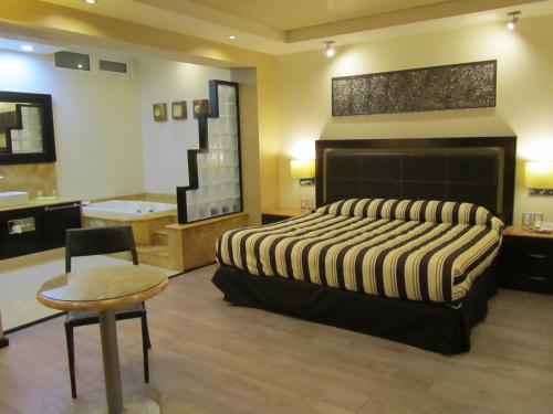1 dormitorio con 1 cama grande y baño en Hotel Colonial, en Teziutlán