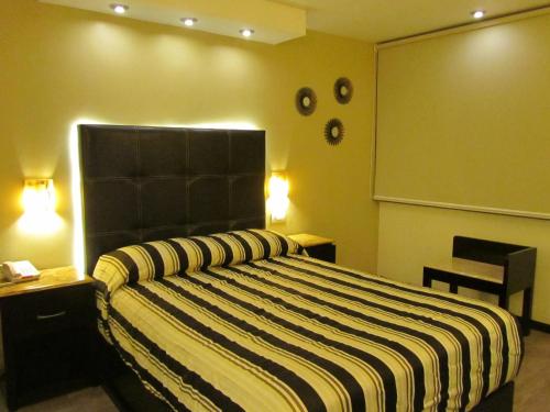 a bedroom with a large bed with a black headboard at Hotel Colonial in Teziutlán