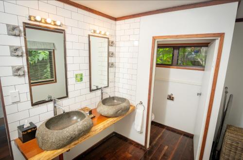 une salle de bains avec deux lavabos sur un comptoir dans l'établissement Qamea Resort & Spa, à Qamea
