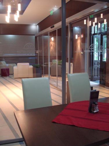 a dining room with a table and two chairs and a room with a view at Hotel Fürdőház in Nyíregyháza