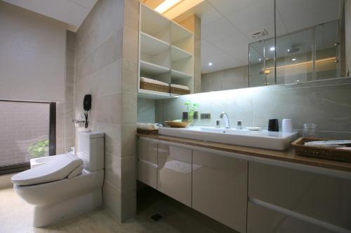 a white bathroom with a toilet and a sink at Darlon Hotel in Hsinchu City