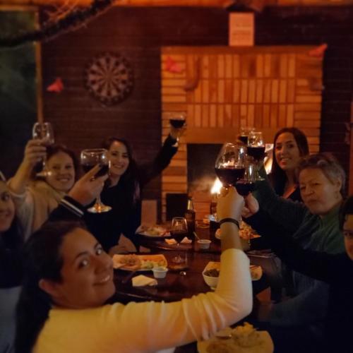 a group of people sitting around a table holding up wine glasses at Casa Mochila in Salento