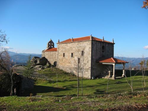 un antiguo edificio en la cima de una colina de hierba en CASA Eiró, en Lobios
