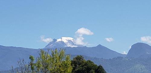a snow covered mountain in the distance with trees and mountains at Casa Mochila in Salento