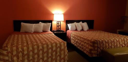 a hotel room with two beds and a lamp at Howard Johnson by Wyndham Flagstaff University West in Flagstaff