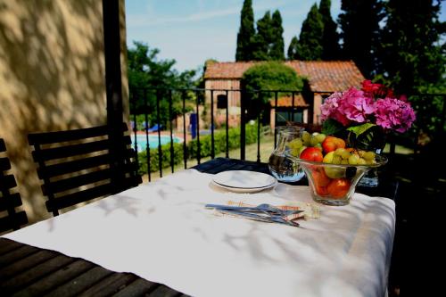 a table with a bowl of fruit and a bowl of flowers at Agriturismo I Moricci in Peccioli