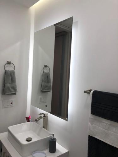 W łazience znajduje się biała umywalka i lustro. w obiekcie New Modern Studio w mieście Buga