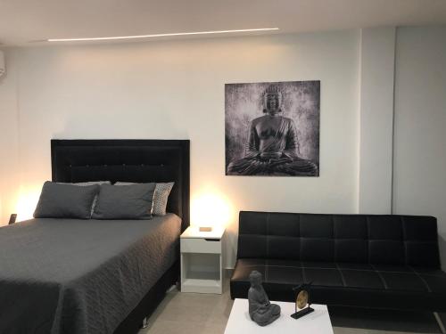 sypialnia z łóżkiem, kanapą i obrazem w obiekcie New Modern Studio w mieście Buga