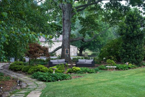 a garden with two couches sitting under a tree at Peppers Manor House in Sutton Forest