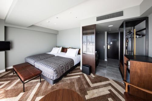 a hotel room with a bed and a television at SHIBUYA STREAM HOTEL formerly Shibuya Stream Excel Hotel Tokyu in Tokyo