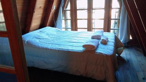 a bedroom with a bed with towels on it at Tierra Mandarina Cabañas in Gualeguaychú