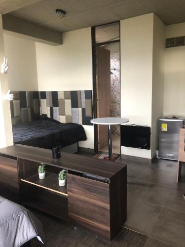 a bedroom with a bed and a table in it at APTO 102 EN "ABADIA de TOMINE" in Guatavita
