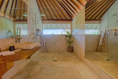 ein großes Bad mit einer Dusche und einem Waschbecken in der Unterkunft Mayana Villas in Canggu