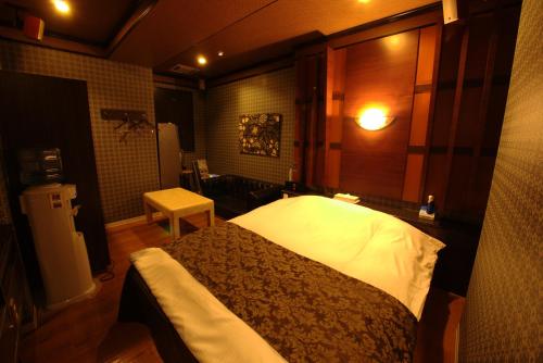 a bedroom with a bed and a table in it at Hotel Allure (Adult Only) in Nagoya
