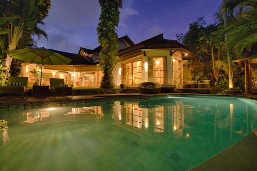 a swimming pool in front of a house at Mayana Villas in Canggu