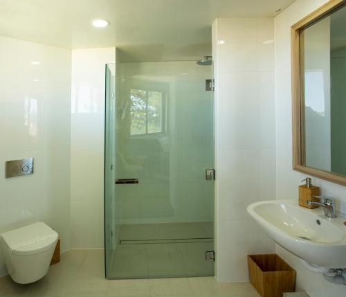 y baño con ducha, aseo y lavamanos. en Oceanside Resort - Absolute Beachfront Apartments, en Gold Coast