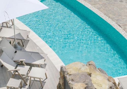 an overhead view of a large swimming pool with chairs at Villa Caruso in Ischia