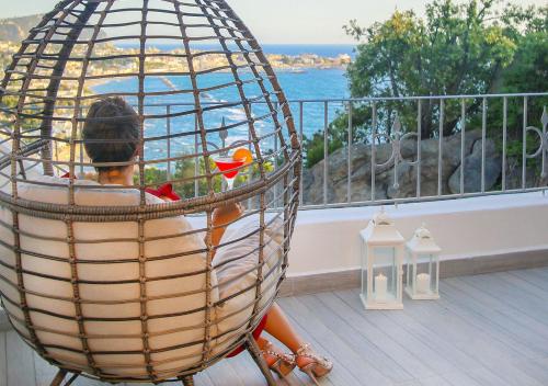 a child sitting in a bird cage on a balcony at Villa Caruso in Ischia