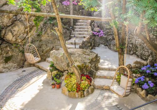 a set of stairs with flowers and a swing at Villa Caruso in Ischia