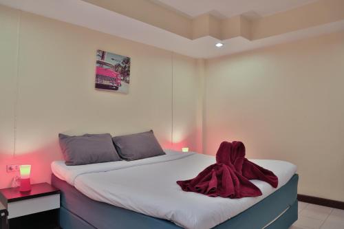 a bedroom with a bed with a red blanket on it at Harrys Hotel Bar & Restaurant in Pattaya Central