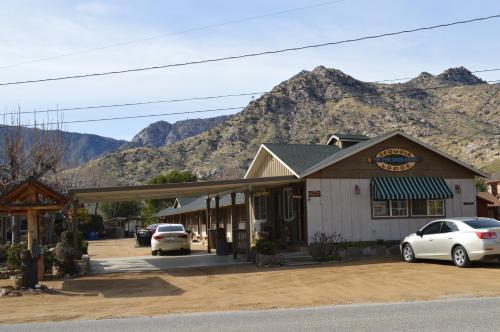 a building with cars parked in front of a mountain at Sequoia Lodge in Kernville