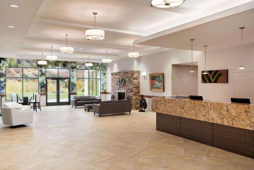 a lobby with a waiting room with couches and a fireplace at Wyndham Garden State College in State College
