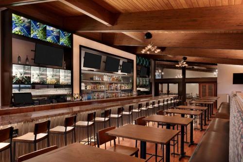 a restaurant with tables and chairs and a bar at Wyndham Garden State College in State College