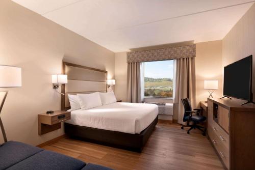 a hotel room with a bed and a window at Wyndham Garden State College in State College