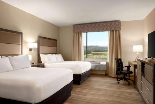 a hotel room with two beds and a window at Wyndham Garden State College in State College