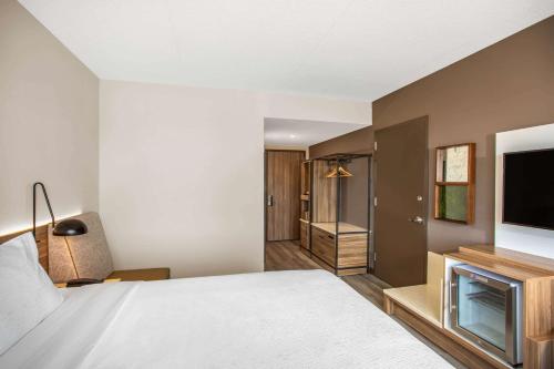 a bedroom with a bed and a flat screen tv at Wyndham Garden Ft Lauderdale Airport & Cruise Port in Dania Beach