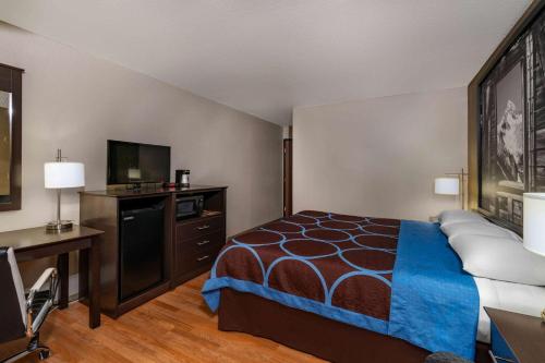 a hotel room with a bed and a flat screen tv at Super 8 by Wyndham Cortez/Mesa Verde Area in Cortez