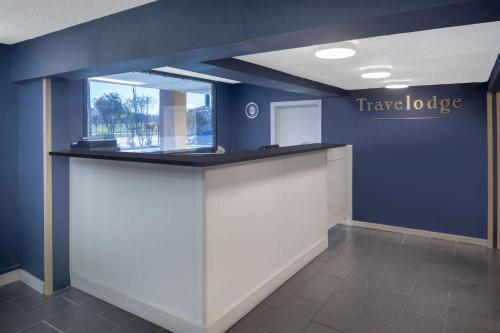 an office lobby with a counter with a have tobacco sign on the wall at Travelodge by Wyndham Savannah Area/Richmond Hill in Richmond Hill
